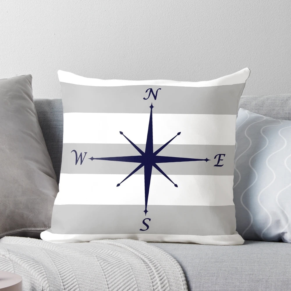 Navy blue compass motif on a silver gray and white striped decorative throw pillow.