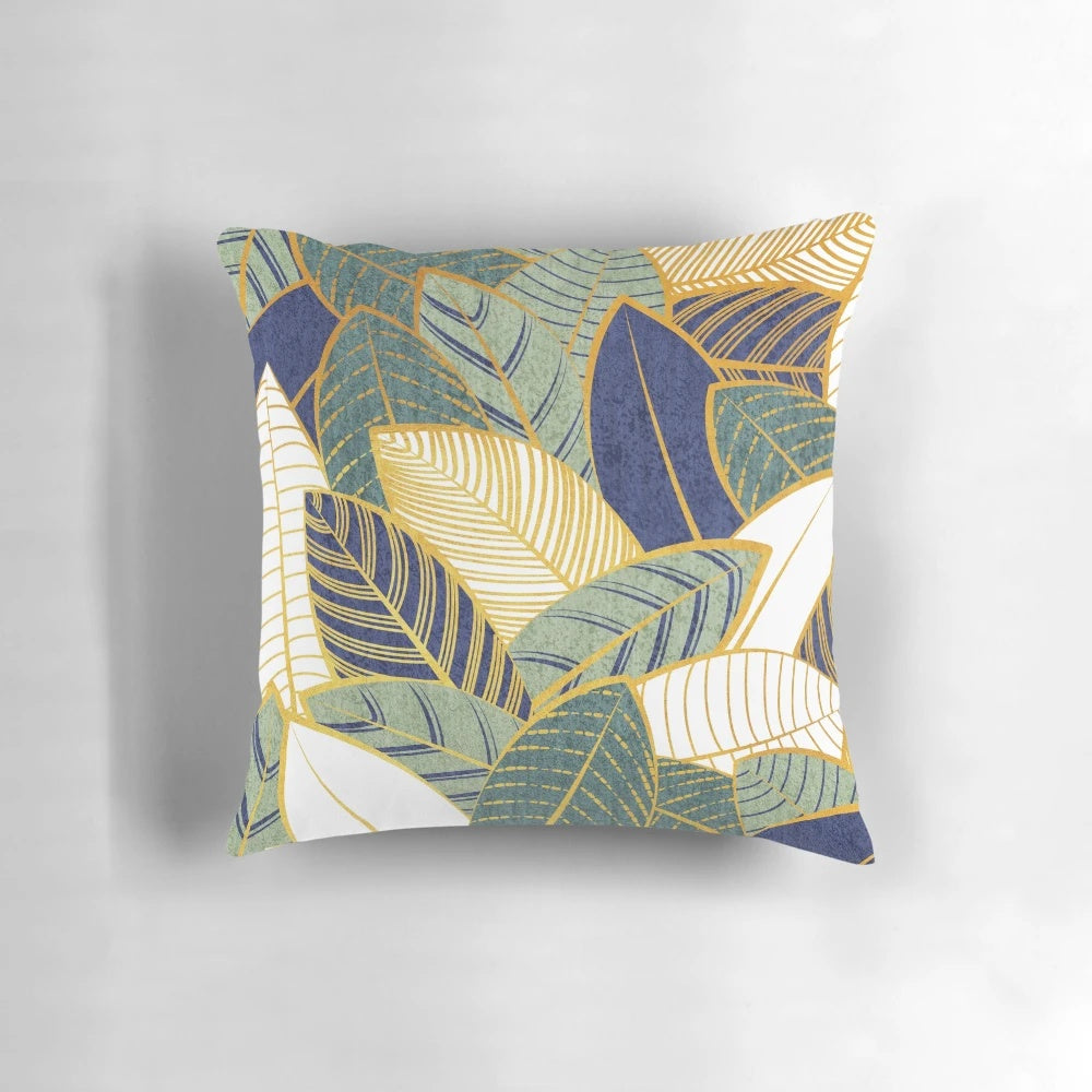 Decorative throw pillow with navy blue, pine, and sage green leaves with golden lines