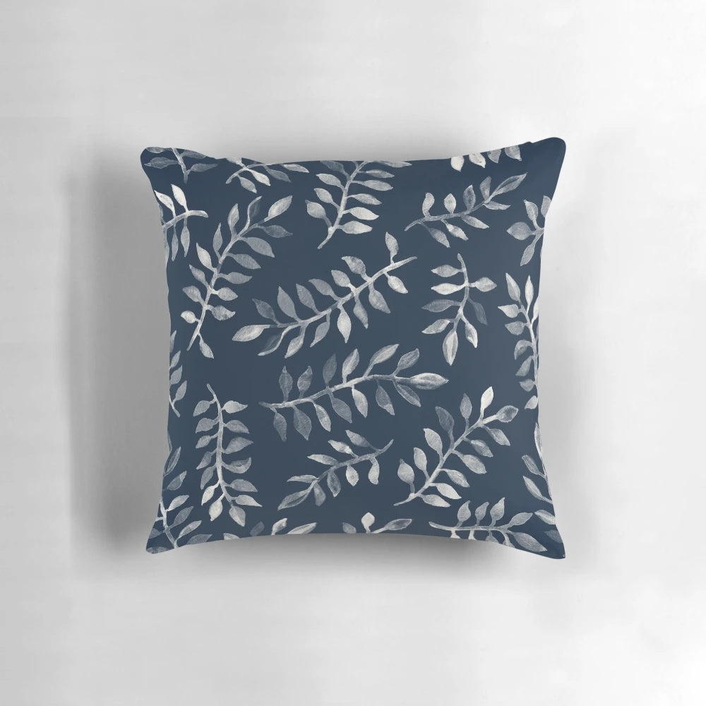 Navy blue and white hand-painted throw pillow with a botanical leaf pattern