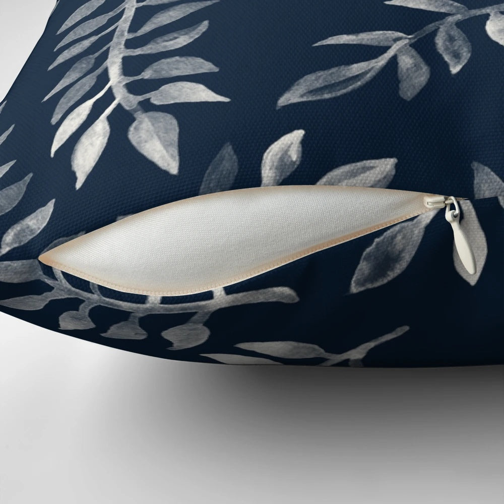 Navy blue and white hand-painted throw pillow with a botanical leaf pattern