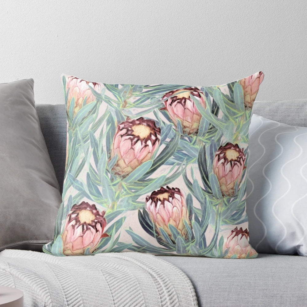 Vibrant painted protea neriifolia flower pattern on a soft, dusty pink decorative pillow