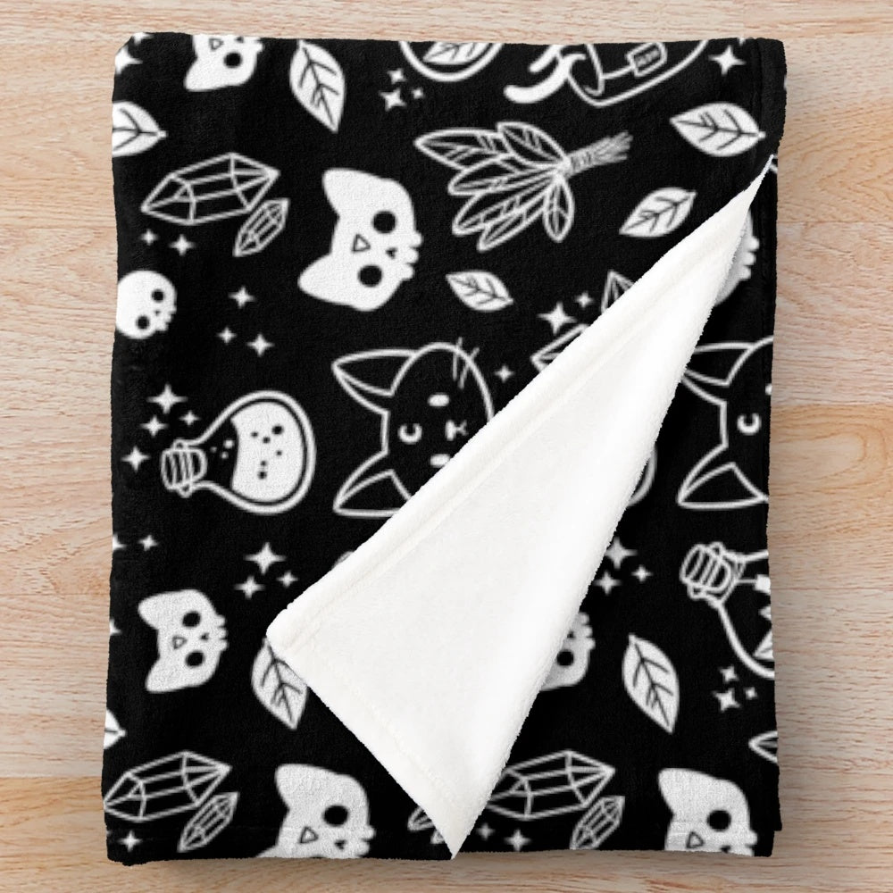 Black and white plush blanket with a witch cat design and occult symbols