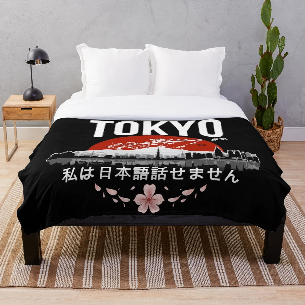 Plush blanket with "I Don't Speak Japanese" design, featuring Japanese elements like cherry blossoms and Tokyo