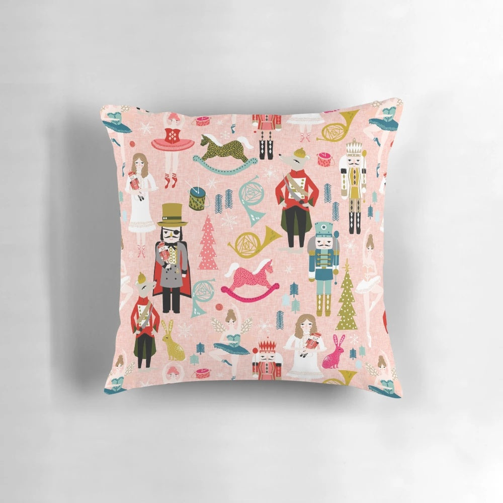 Blush-colored Nutcracker ballet-themed pillow with dance and classical music motifs