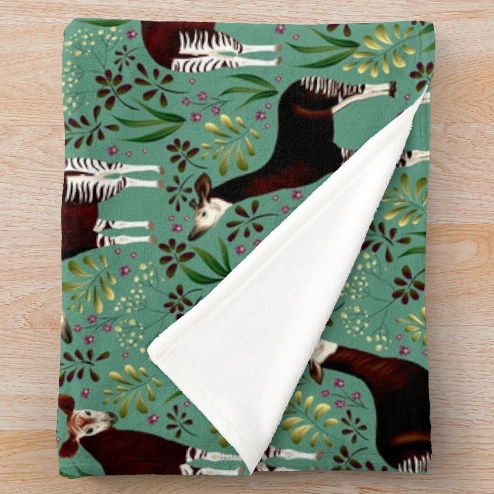 Okapi-inspired plush blanket featuring a vibrant forest giraffe design
