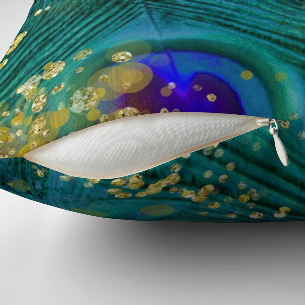 A decorative throw pillow featuring a dreamy design of peacock feathers in shades of teal and purple with a glimmering gold accent.