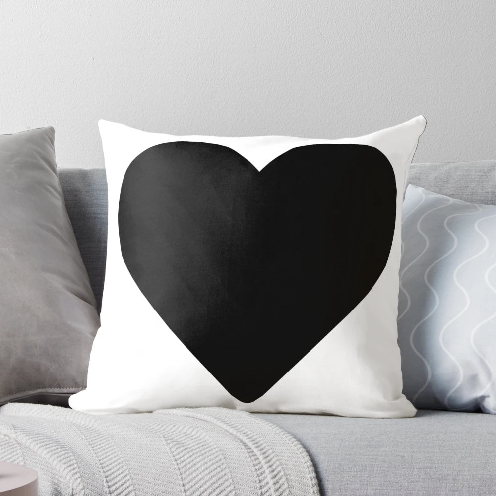 Photograph of a large black heart-shaped pillow, a cozy and enchanting addition to any living space.