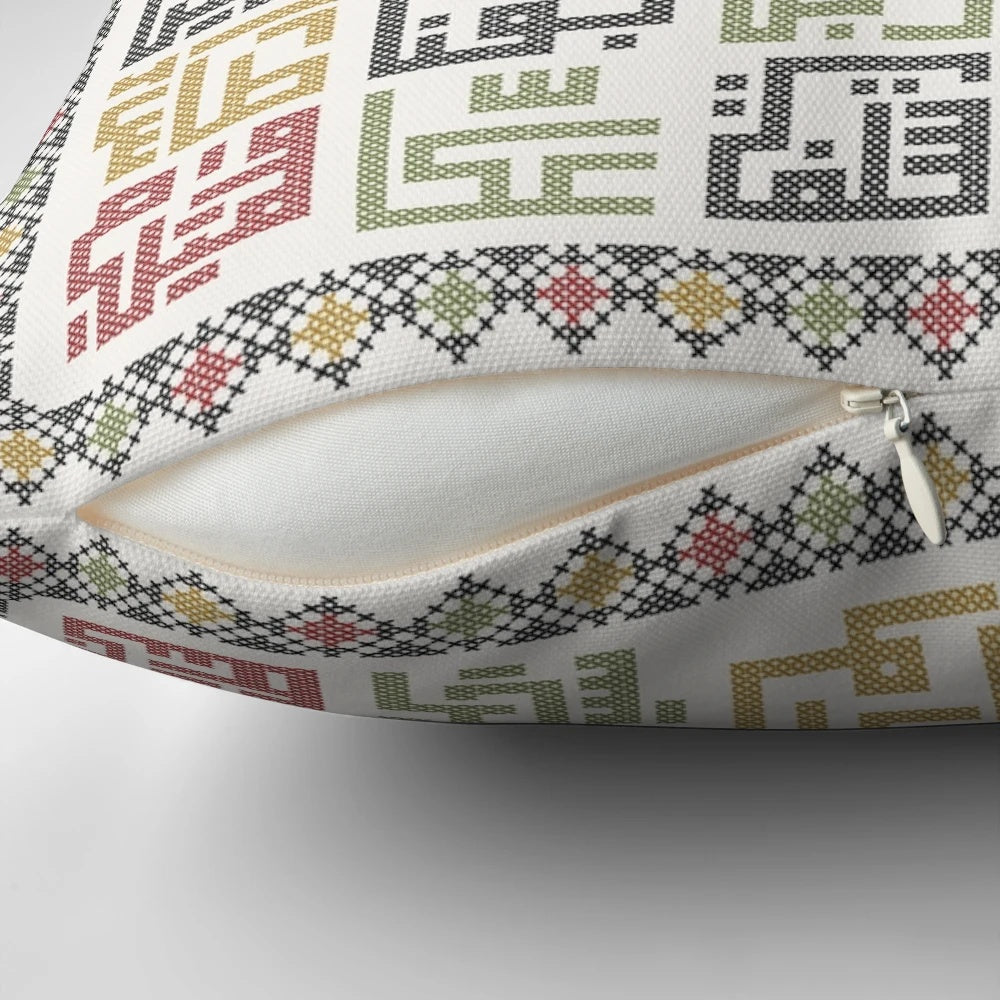 Decorative pillow featuring traditional Palestinian Tatreez embroidery with names of cities across Palestine.