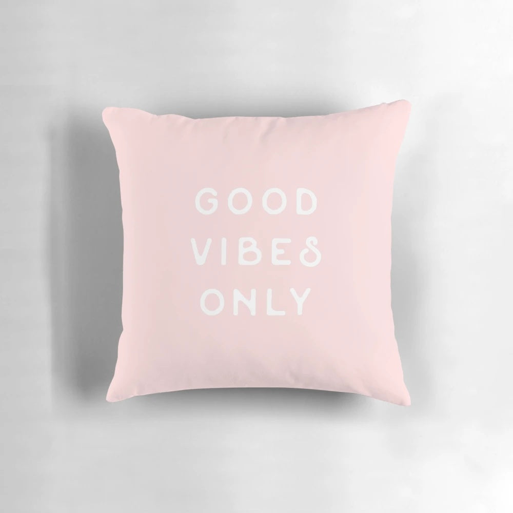 Pastel pink and blush colored pillow with small text, evoking a minimalist, California desert aesthetic.
