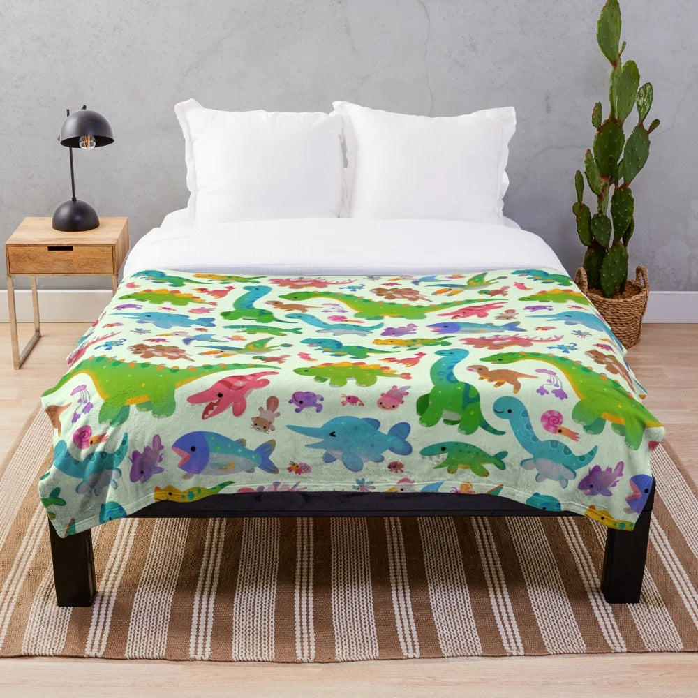 Pastel colored plush blanket with dinosaur design