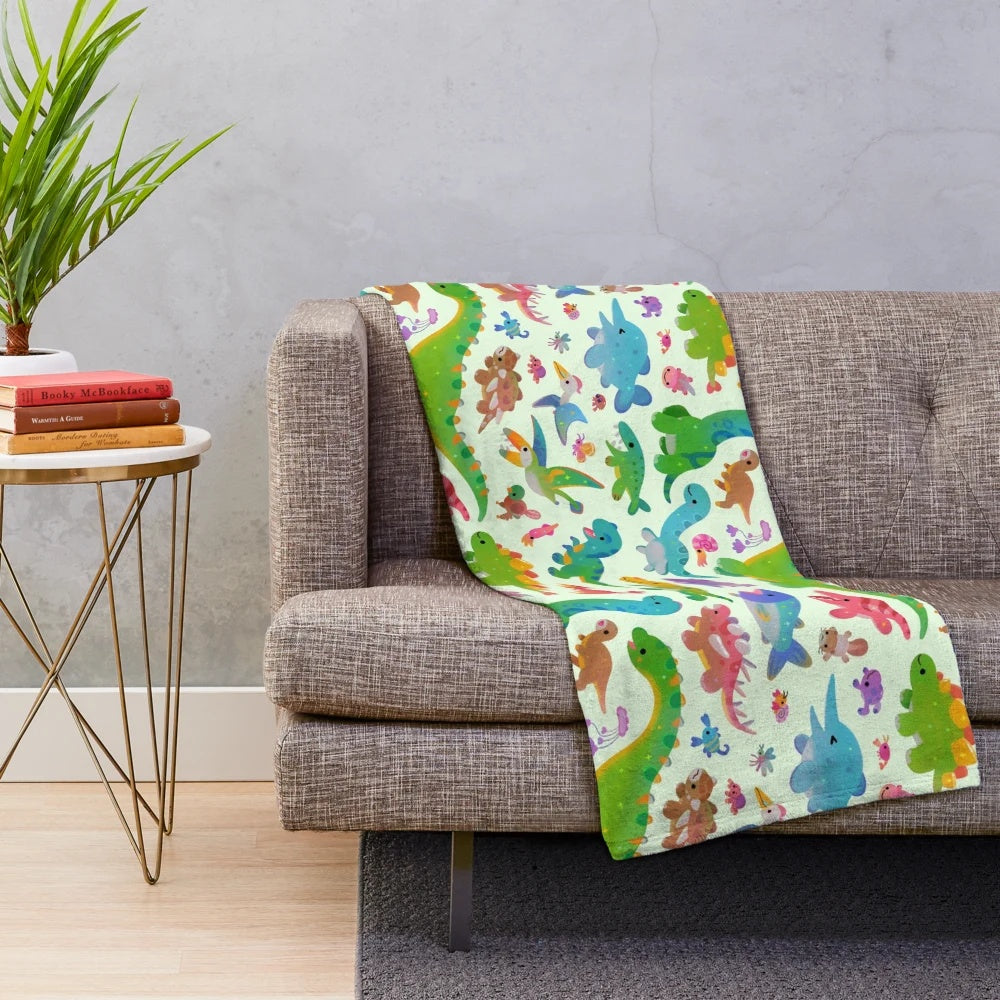 Pastel colored plush blanket with dinosaur design