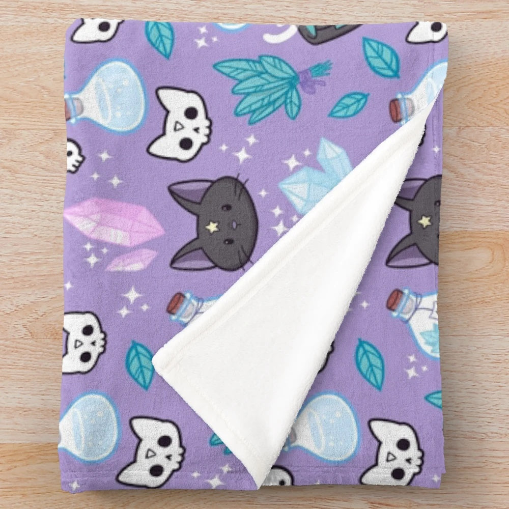 Pastel purple plush blanket with autumn leaf pattern, skull, and cat silhouette design