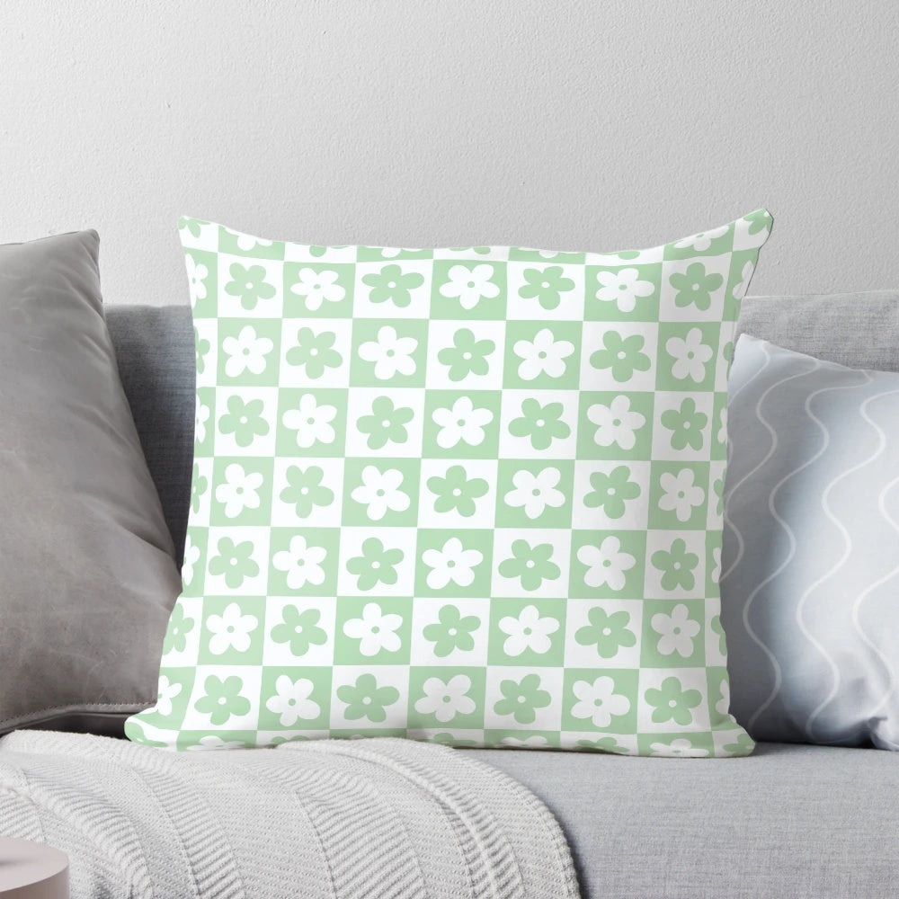 Pastel green and white checkered decorative pillow with a geometric floral pattern