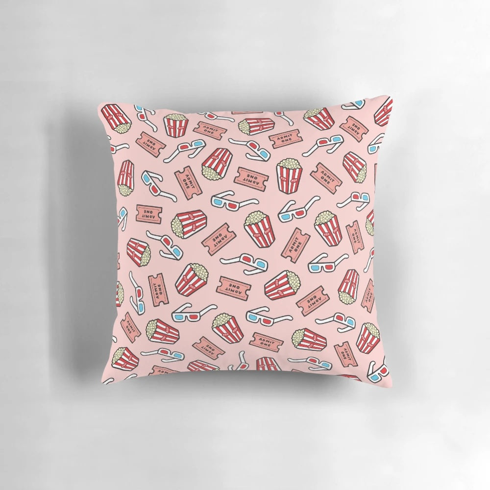 Pastel pink throw pillow with a stylized movie pattern design, featuring popcorn, movie glasses, and a retro 80s aesthetic.