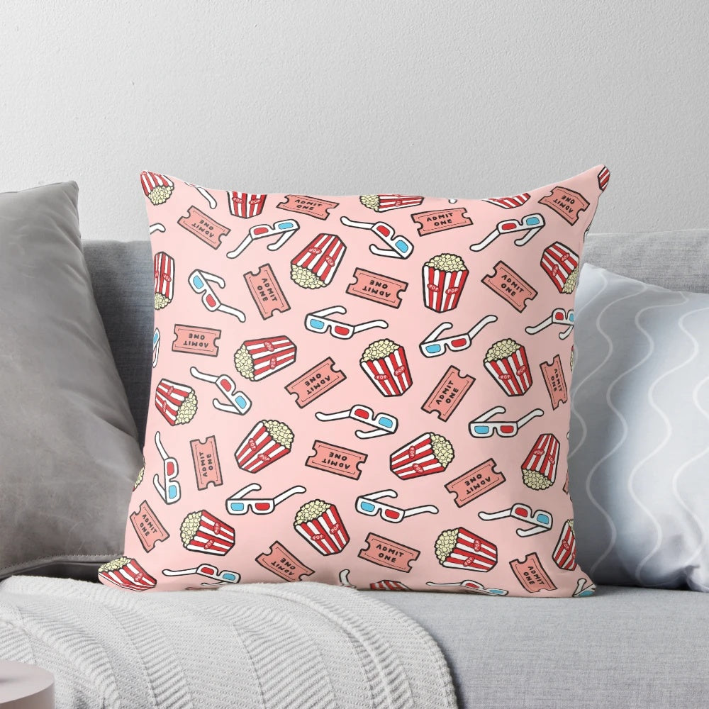 Pastel pink throw pillow with a stylized movie pattern design, featuring popcorn, movie glasses, and a retro 80s aesthetic.