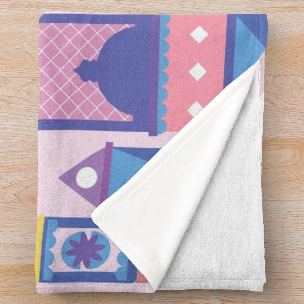 Pastel colored plush blanket with a Disney-inspired cartoon building design