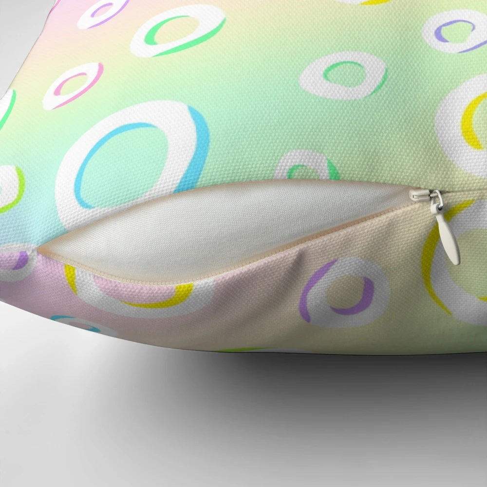 Pastel rainbow gradient design with polka dots on a decorative throw pillow