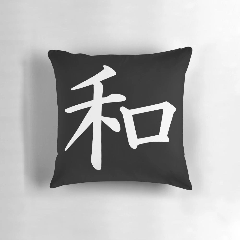 A white decorative pillow with the Japanese kanji character for "peace" printed on it.