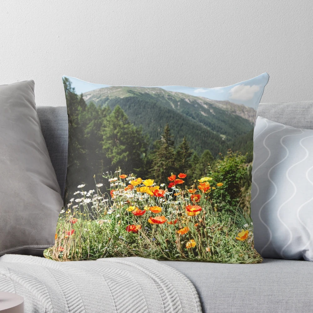 A cozy mountain garden pillow featuring vibrant wildflowers and a serene landscape.