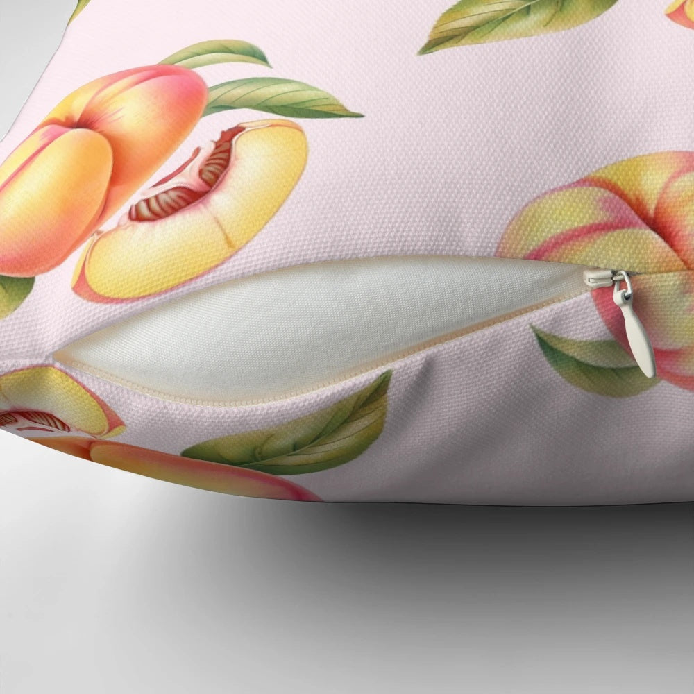 Peach pillow with leaves and a slice of peach on a white background