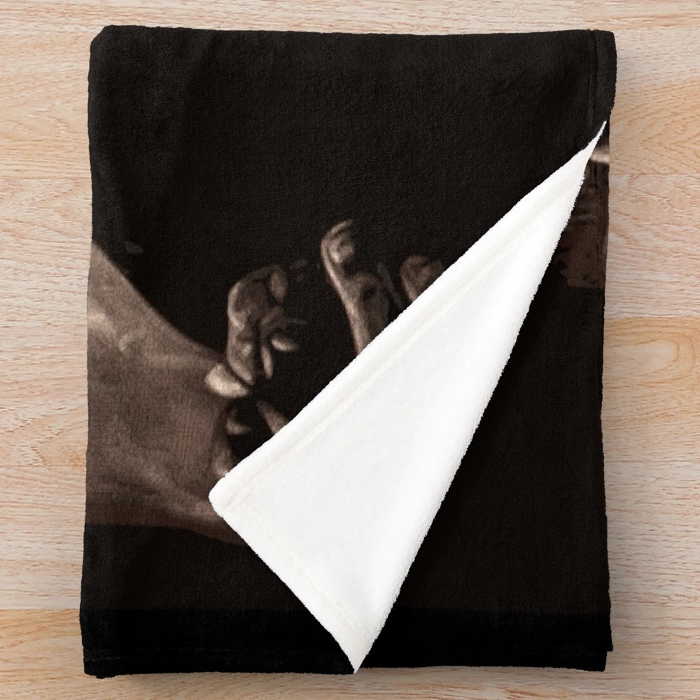 Tommy Shelby from Peaky Blinders smoking a cigarette on a plush blanket
