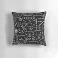 A decorative throw pillow featuring a pattern of chemical element symbols from the periodic table.