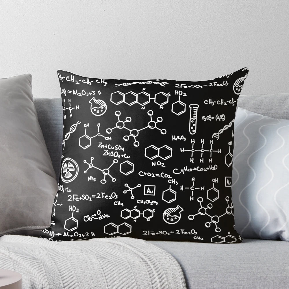 A decorative throw pillow featuring a pattern of chemical element symbols from the periodic table.