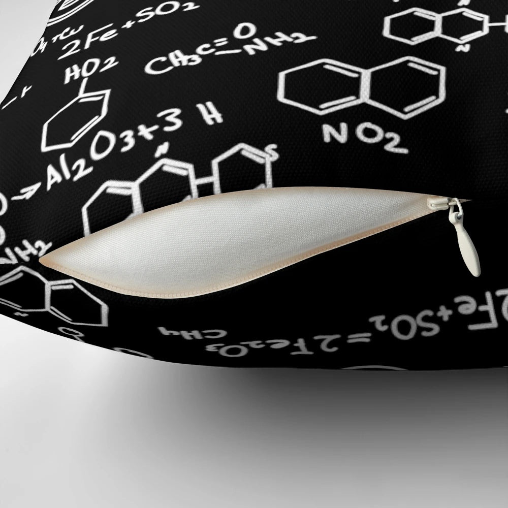 A decorative throw pillow featuring a pattern of chemical element symbols from the periodic table.