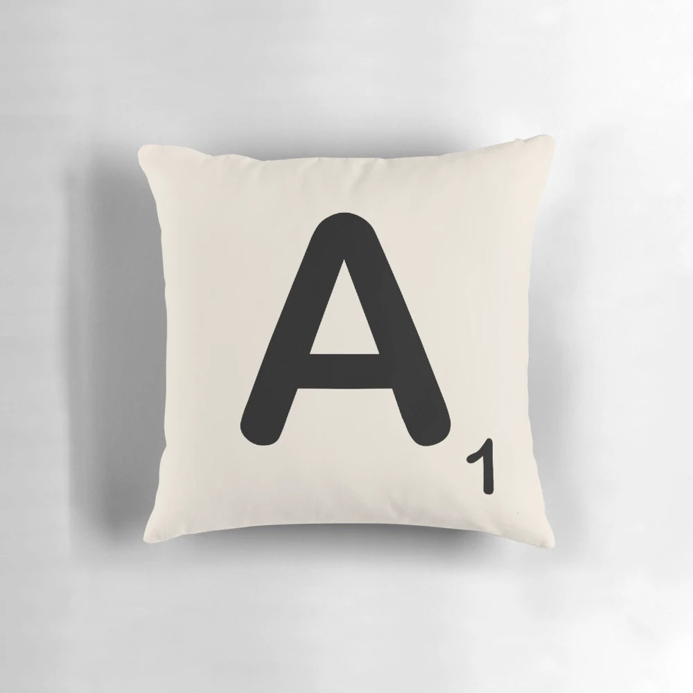 Decorative throw pillow featuring a printed scrabble tile letter design