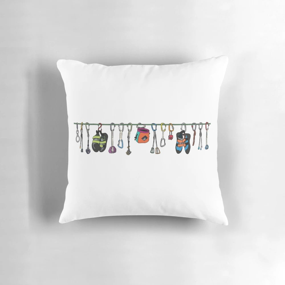 Pillow with colorful illustrations of climbing gear such as ropes, carabiners, and shoes