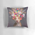 Frida the Pit Bull wearing a colorful flower crown on a decorative pillow
