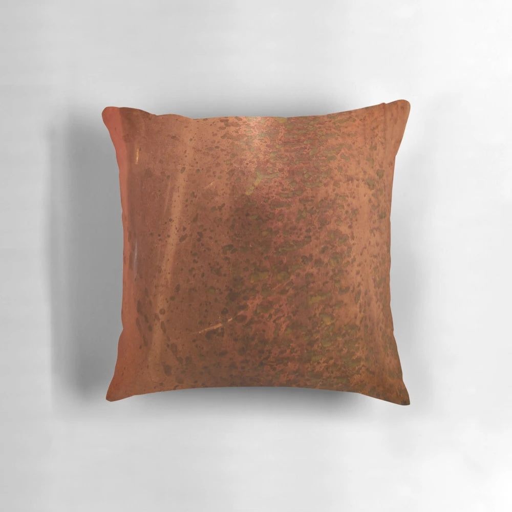 Pitted copper metal pillow with a distressed, aged appearance
