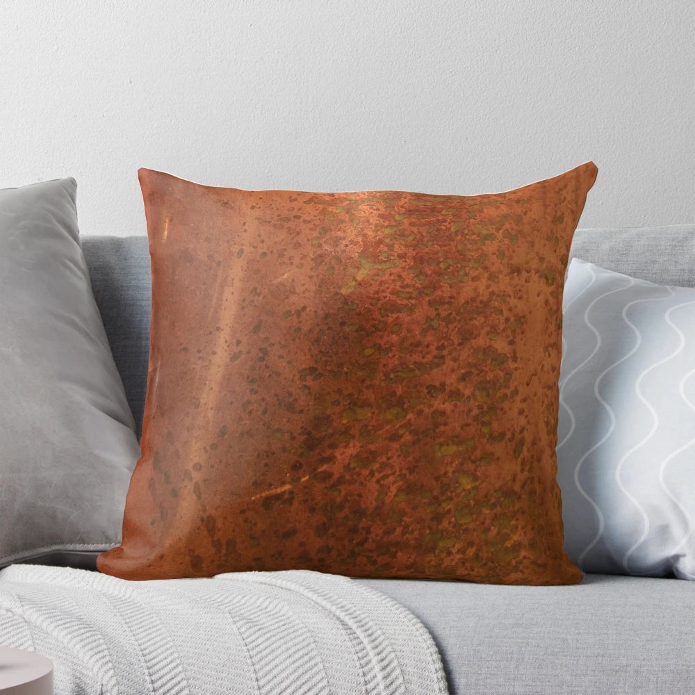 Pitted copper metal pillow with a distressed, aged appearance