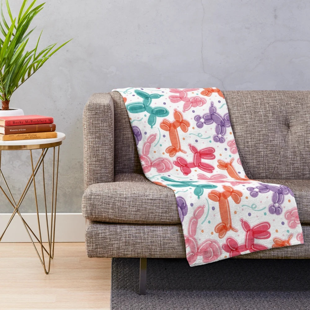 Colorful plush blanket with balloon dog and confetti pattern