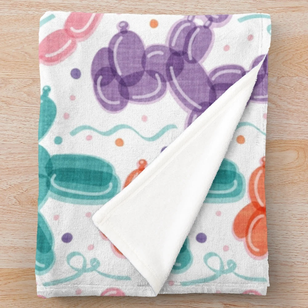 Colorful plush blanket with balloon dog and confetti pattern