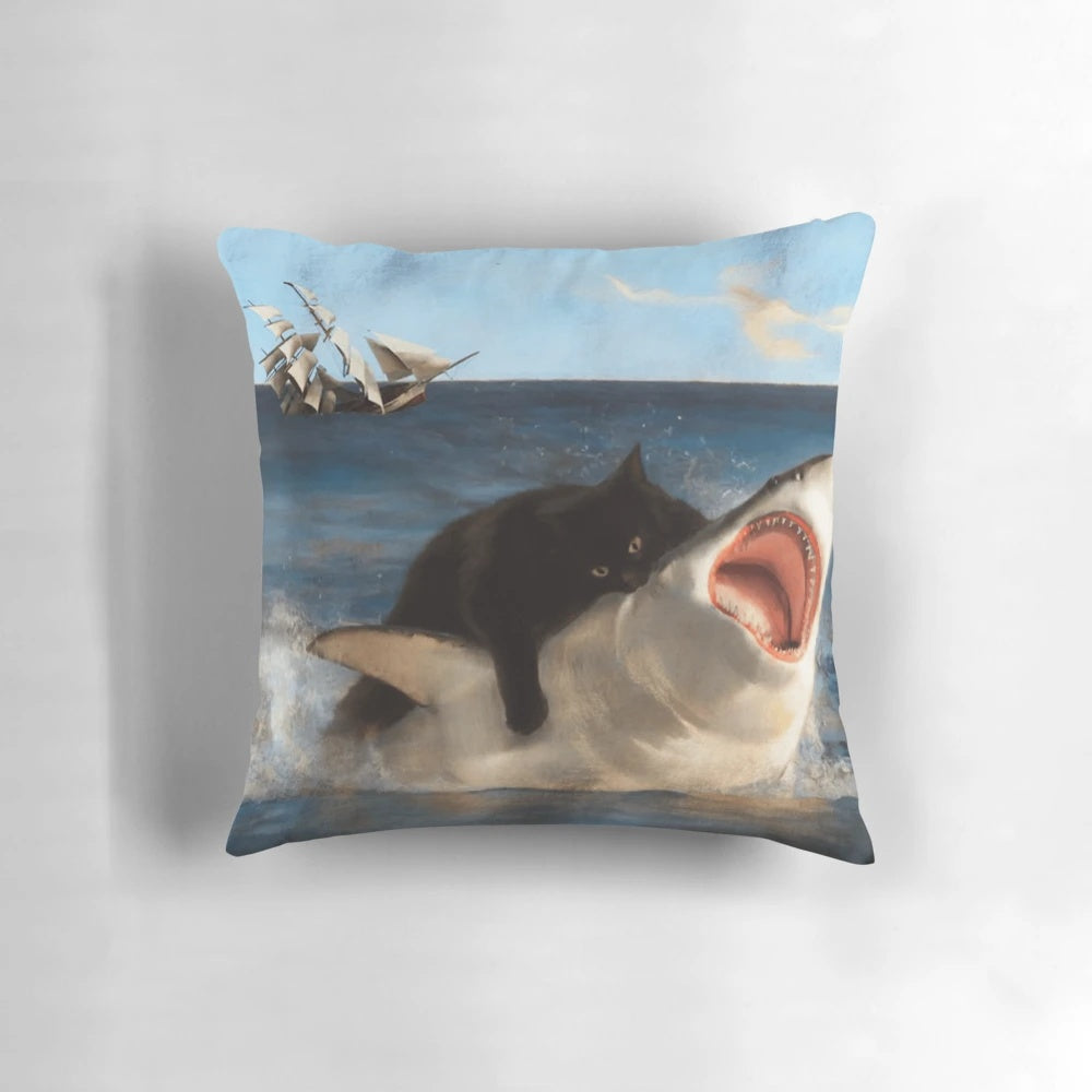 A whimsical illustration of a black kitten playfully attacking a great white shark on a decorative pillow.