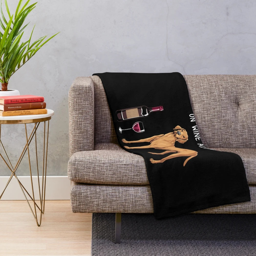 Vizsla dog in a plush blanket with a glass of wine