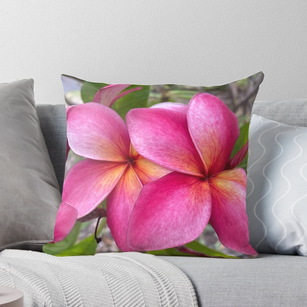 Vibrant plumeria flowers printed on a decorative pillow for a Hawaiian-inspired touch.