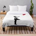 Plush blanket with Banksy's iconic Girl with Red Balloon street art design