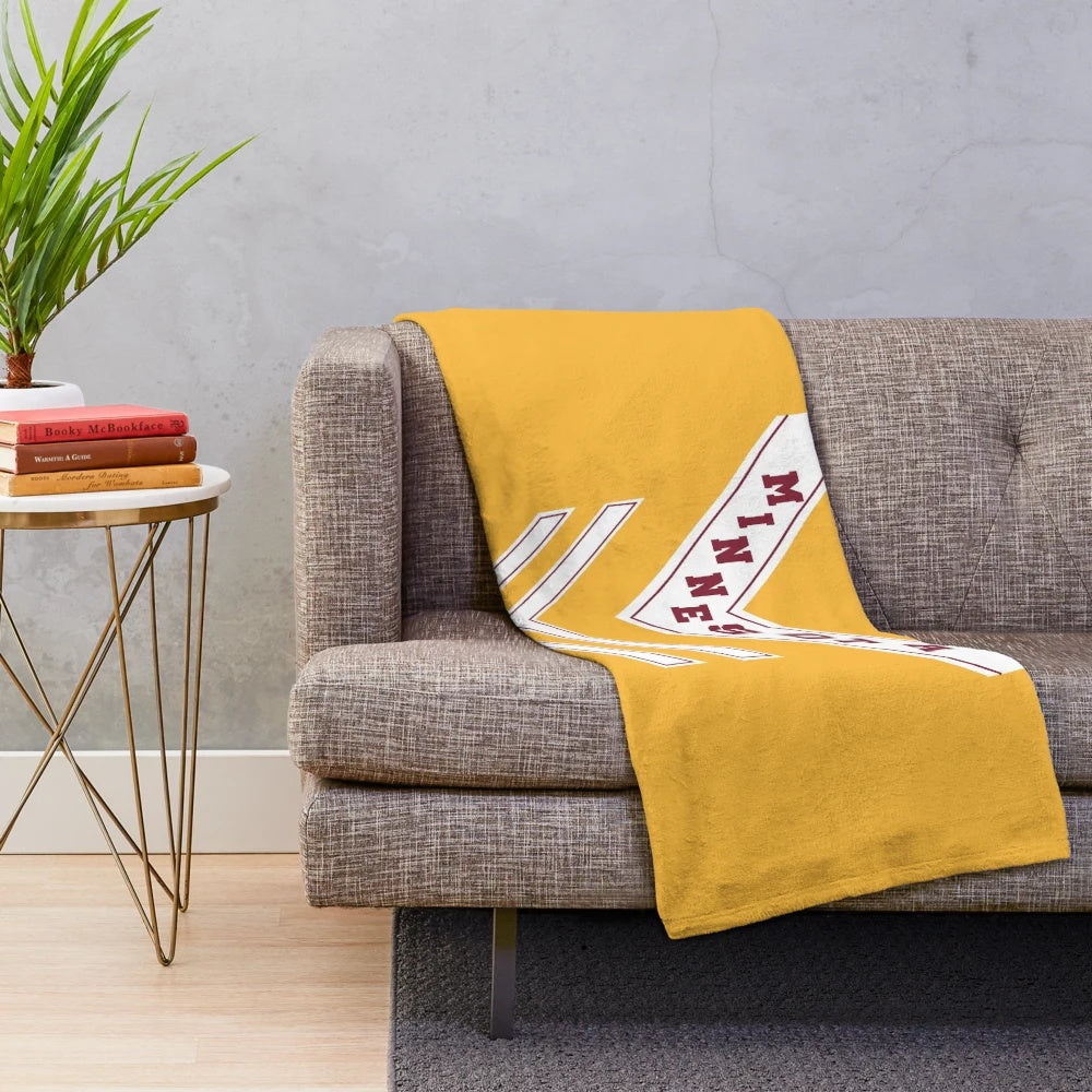 Plush blanket with University of Minnesota marching band uniform chevron design