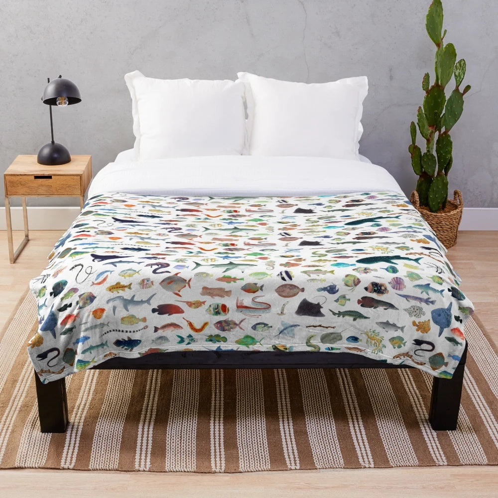 Colorful plush blanket with a variety of marine animals including fish, sharks, and whales
