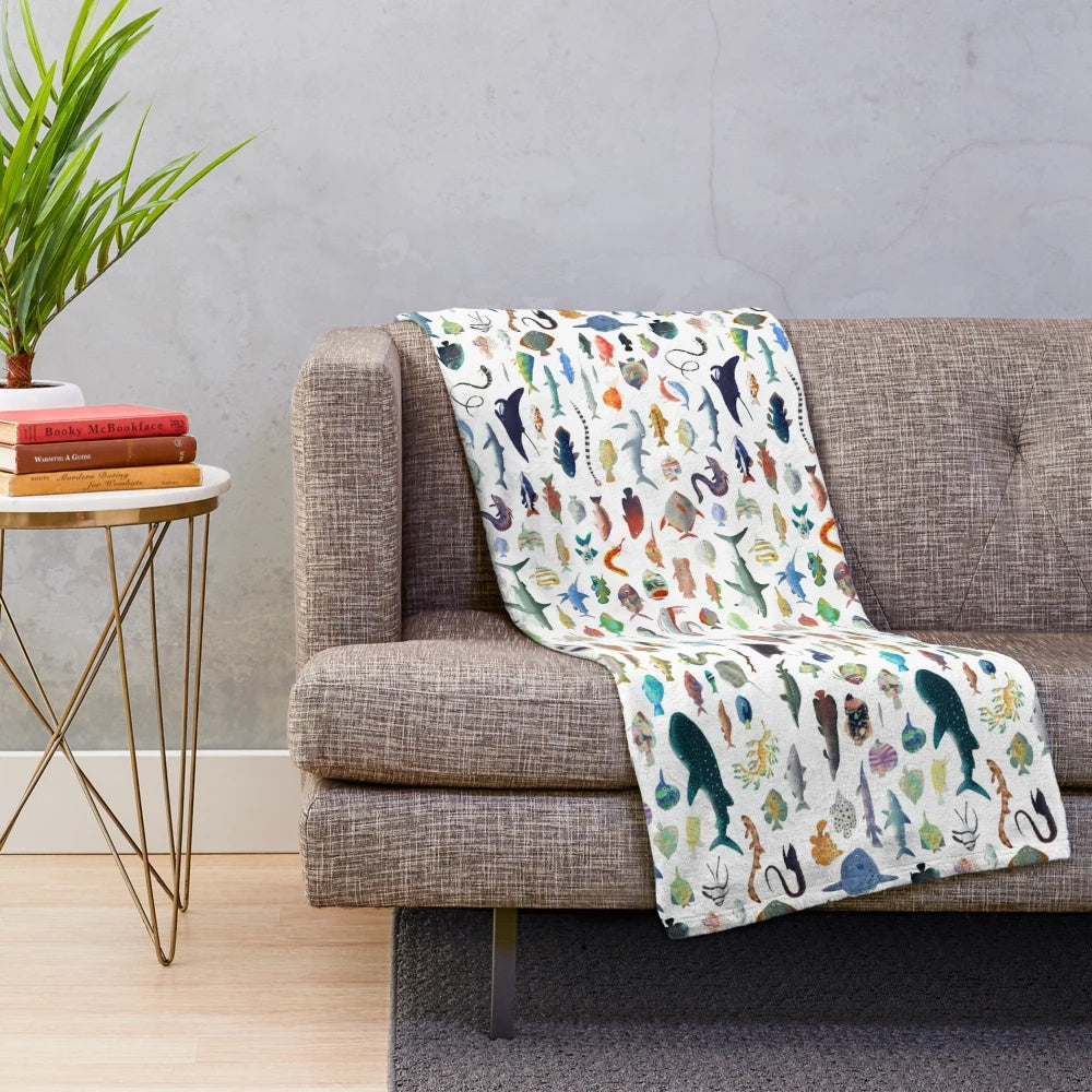 Colorful plush blanket with a variety of marine animals including fish, sharks, and whales