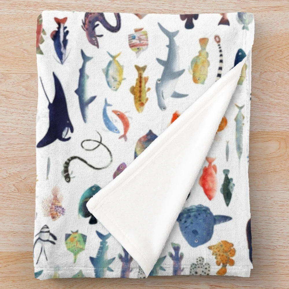Colorful plush blanket with a variety of marine animals including fish, sharks, and whales
