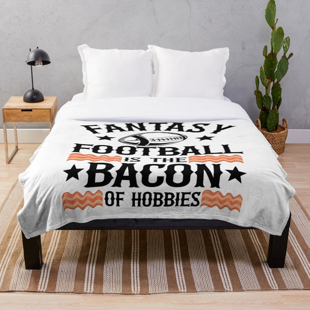 Soft plush blanket with a retro "Fantasy Football is the Bacon of Hobbies" design, great for football fans and collectors.