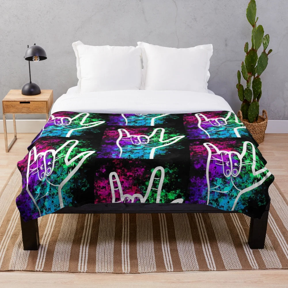 Soft plush blanket featuring a splatter paint design of the American Sign Language "I Love You" sign