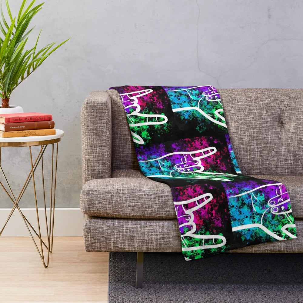 Soft plush blanket featuring a splatter paint design of the American Sign Language "I Love You" sign