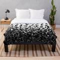 Plush blanket with abstract raven, crow, and flying birds pattern