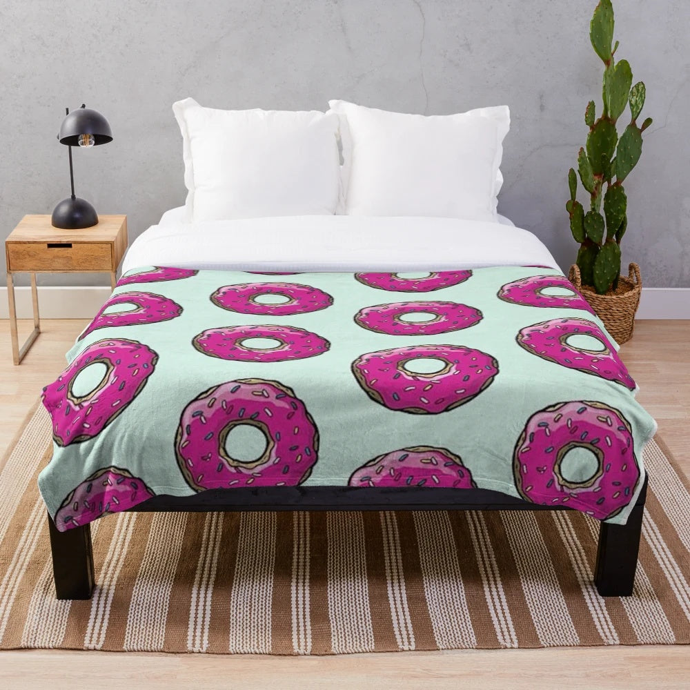 Plush blanket featuring a Simpsons-inspired donut pattern in pink and sprinkles