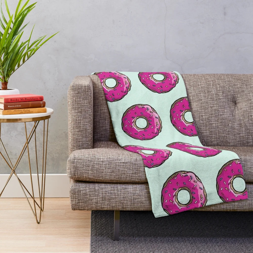 Plush blanket featuring a Simpsons-inspired donut pattern in pink and sprinkles