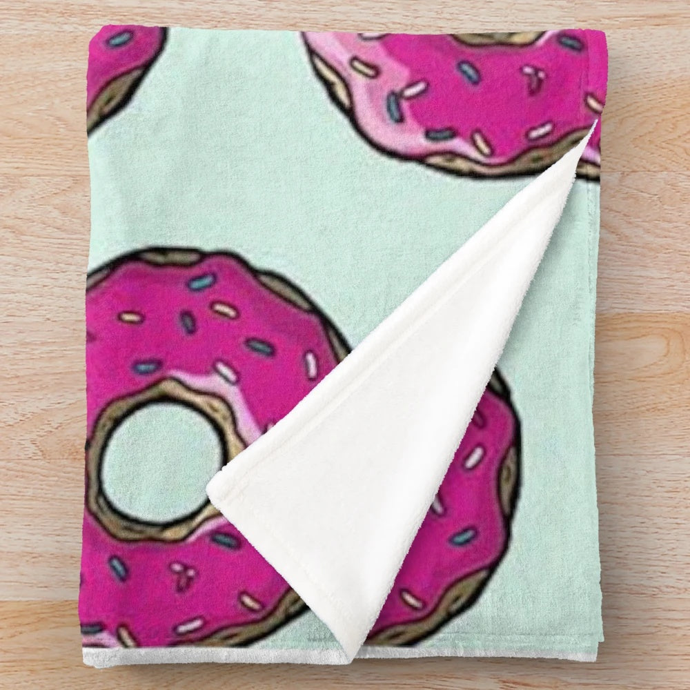 Plush blanket featuring a Simpsons-inspired donut pattern in pink and sprinkles